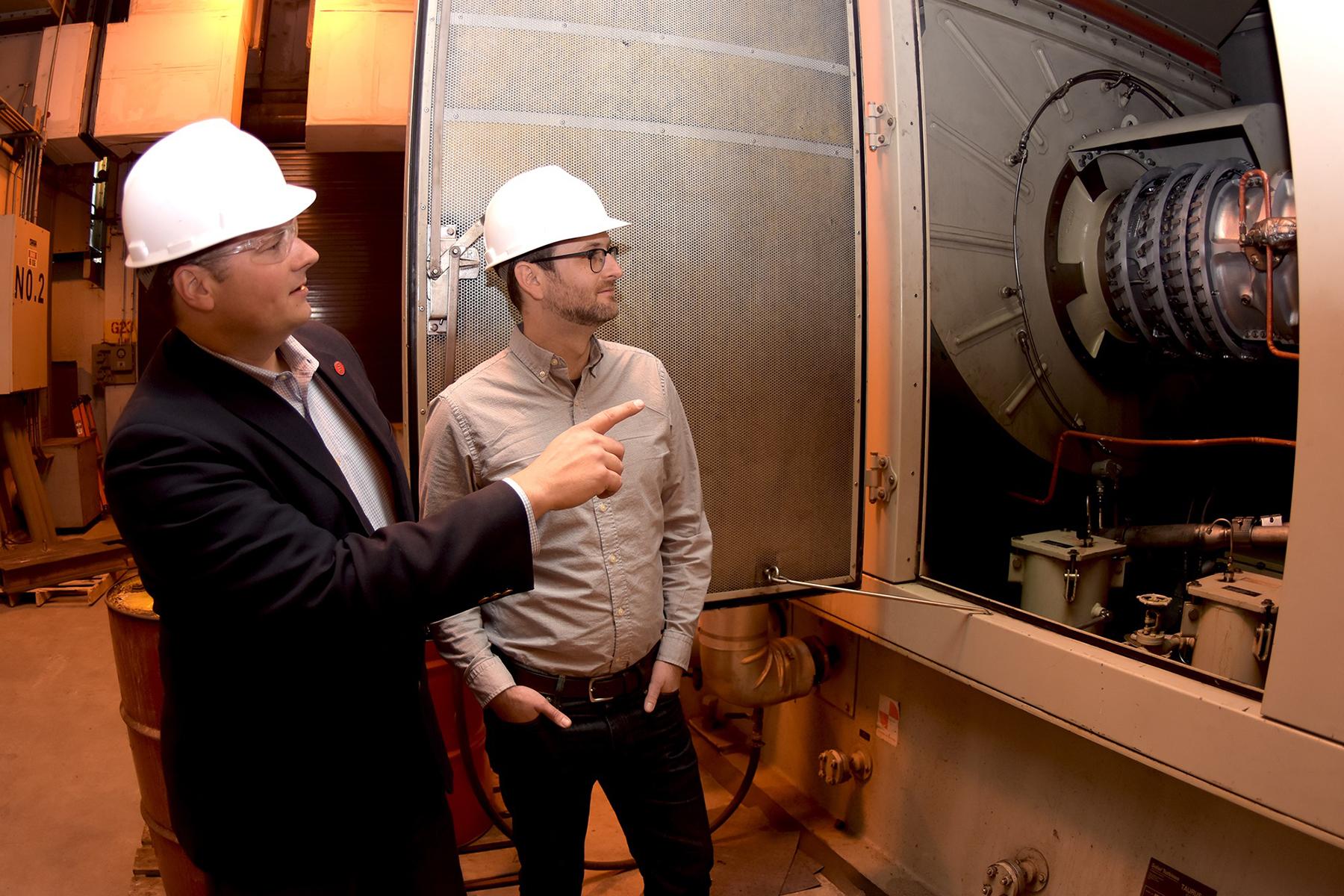 Cliff Haefke, director of the UIC Energy Resources Center, left, and policy analyst Graeme Miller analyze the 7-megawatt combined heat and power combustion turbine at the UIC West Campus Utilities Plant. (Courtesy University of Illinois at Chicago)