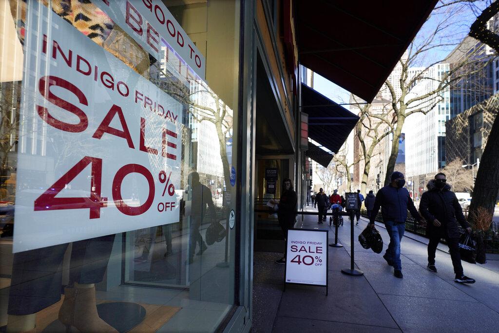 Shoppers pass an Indigo Friday 40% Off sign Saturday, Nov. 28, 2020, on Chicago’s famed Magnificent Mile shopping district. (AP Photo / Charles Rex Arbogast)