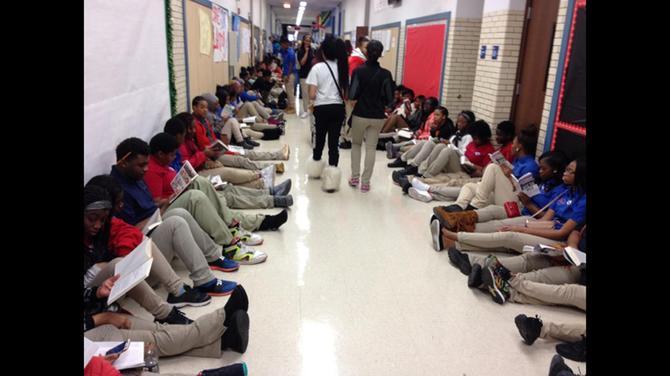 Students throughout the DuSable campus sat outside their classrooms reading last December to protest the firing of librarian Sara Sayigh. She was re-hired by the district, but had her position cut to half-time during the latest round of CPS staff cuts. (Courtesy of Alvita Payne)