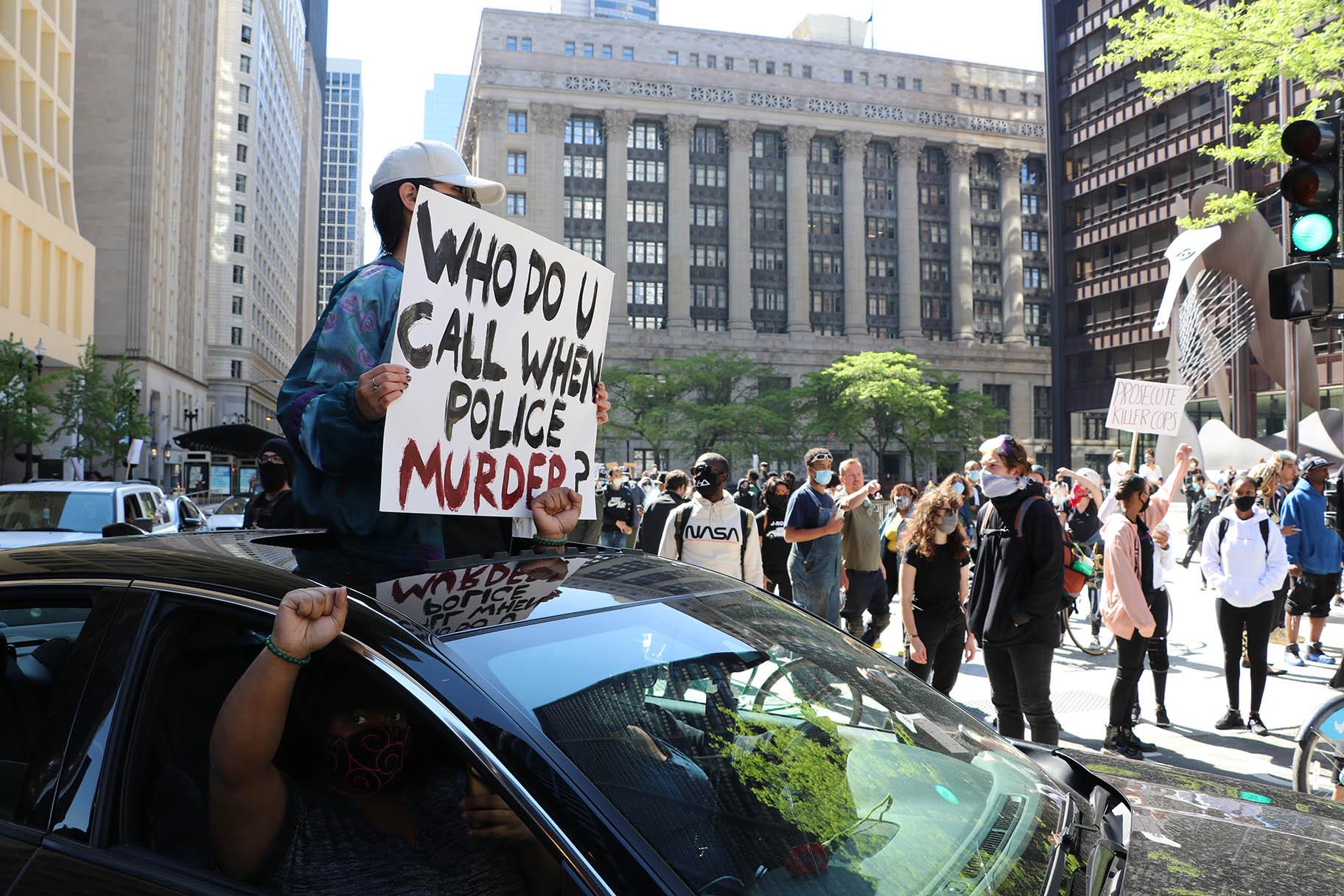 Several motorists show support by honking their horns and holding signs while circling Daley Plaza. (Evan Garcia / WTTW News)