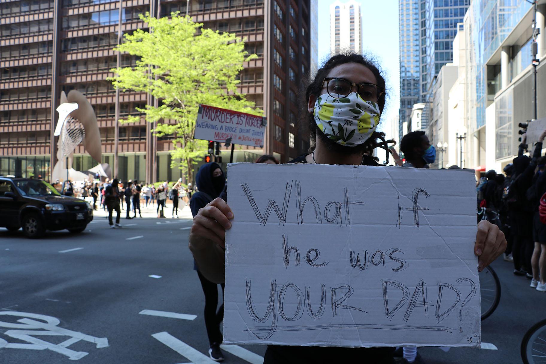 Donovan Walker, 33, of Chicago, holds a sign that reads: “What if he was YOUR DAD?: Walker said he lost his father 10 years ago. “When George [Floyd] got killed, I felt like another family member of mine got killed – and that cut me deep,” Walker said. “This one hurts a little more – I feel like I saw a modern-day lynching and that doesn’t feel good at all.” (Evan Garcia / WTTW News)