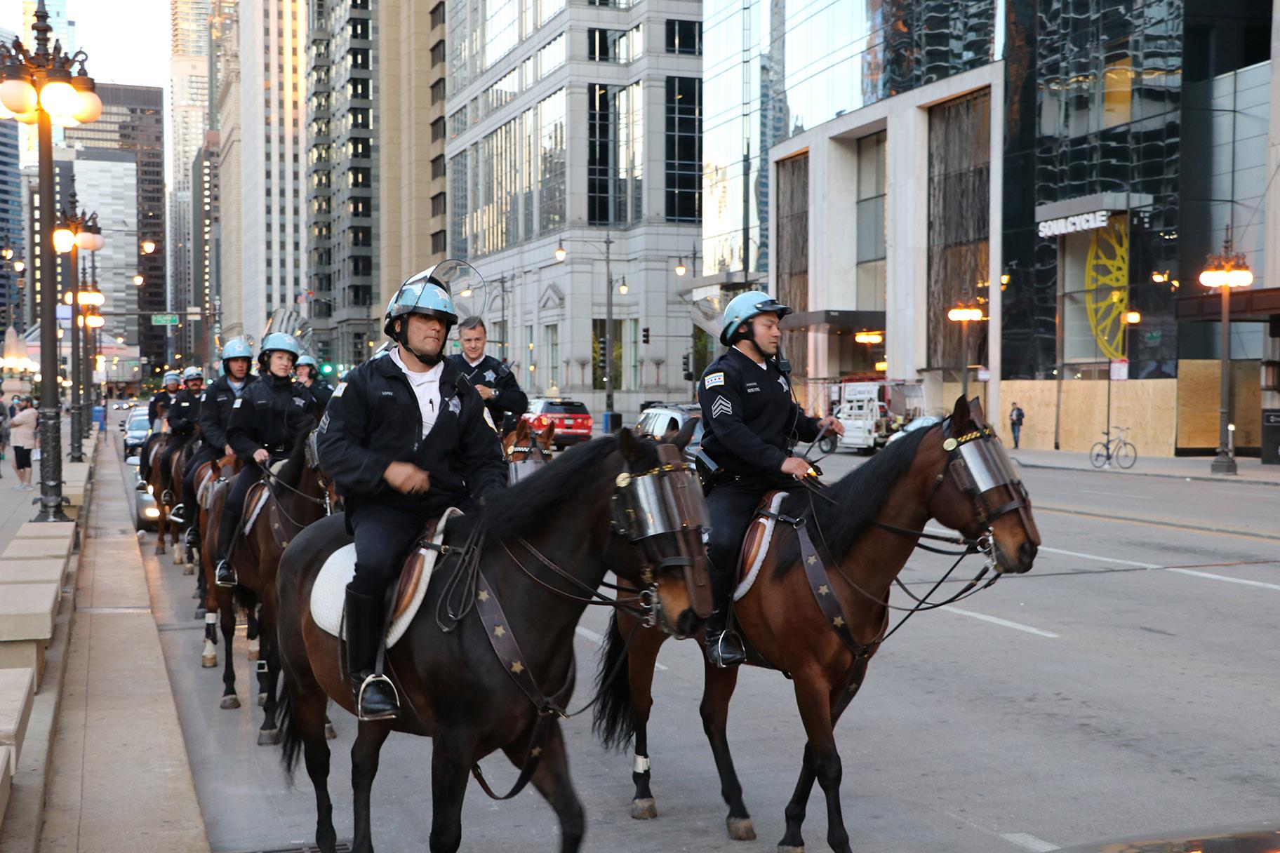 Police officers on horseback line up near the LaSalle Street bridge, the only visibly lowered bridge in the area. (Evan Garcia / WTTW News)