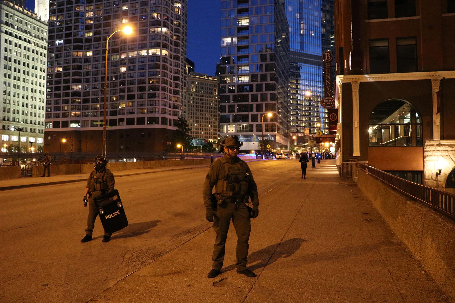 Two members of Chicago Police’s SWAT team block people from traveling northward on Wabash Avenue after the 9 p.m. curfew. Exceptions were made for people who live in the area. (Evan Garcia / WTTW News)