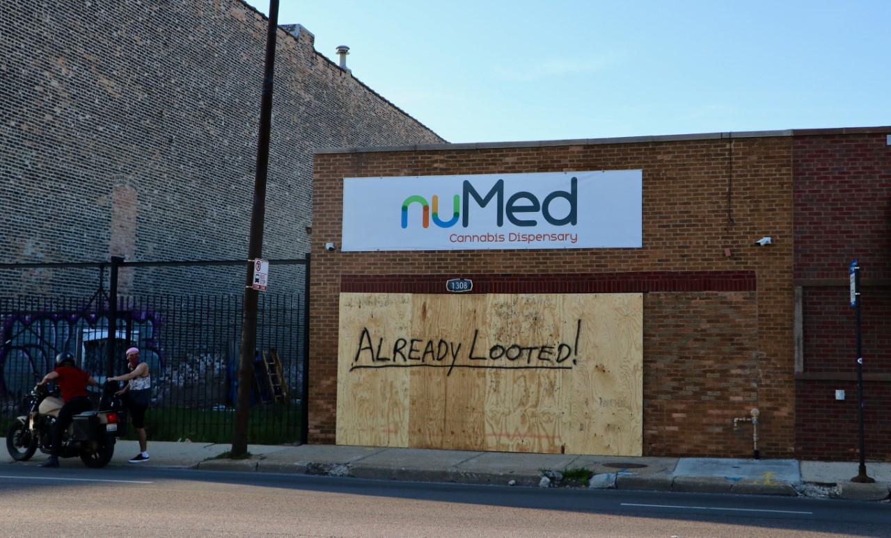 On North Avenue, the board covering a cannabis dispensary reads “Already Looted!” (Evan Garcia / WTTW News)