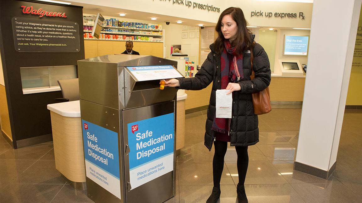 A woman discards medicine at a Walgreens medication disposal kiosk. (Walgreens)