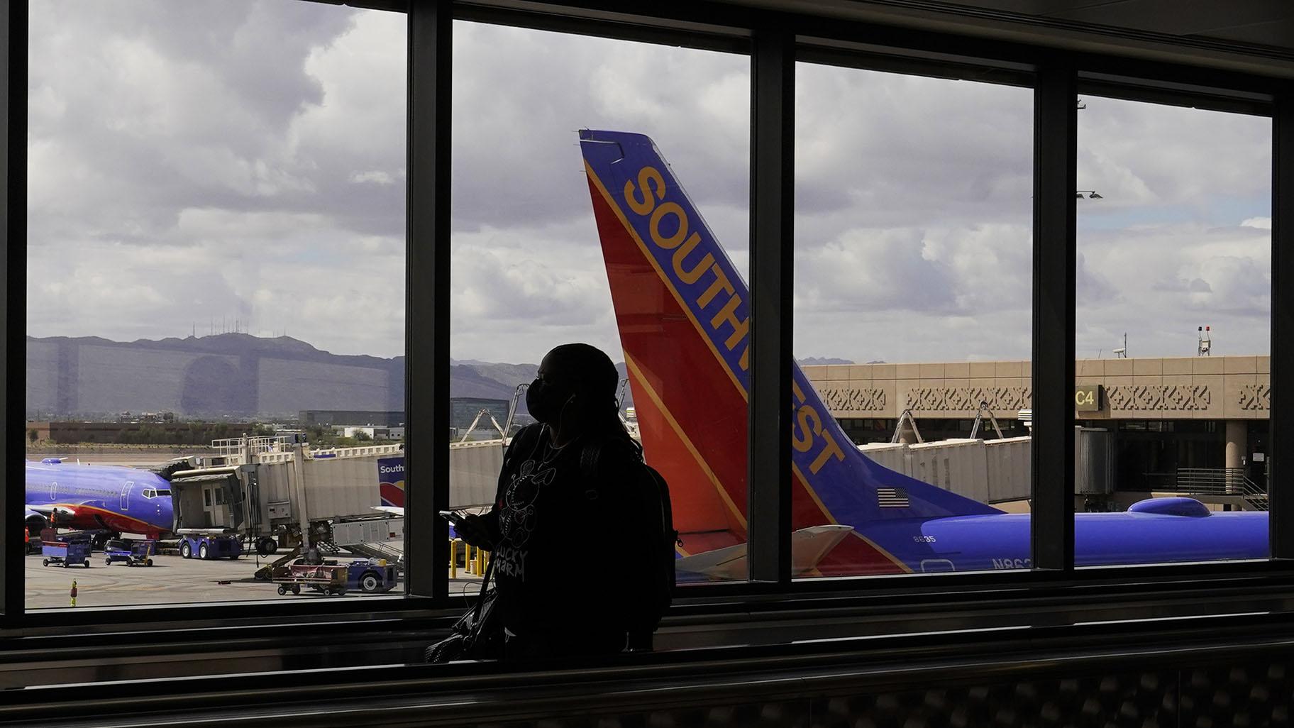 A passenger walks past a Southwest Airlines plane at Sky Harbor International Airport in Phoenix, March 26, 2021. (AP Photo / Sue Ogrocki, File)