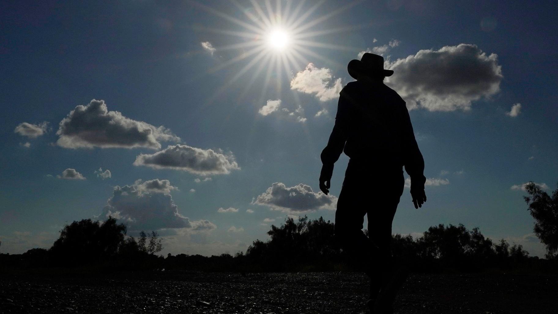 Kayak and canoe outfitter Jessie Fuentes walks along the Rio Grande under a warm sun Thursday, July 6, 2023. (AP Photo / Eric Gay, File)