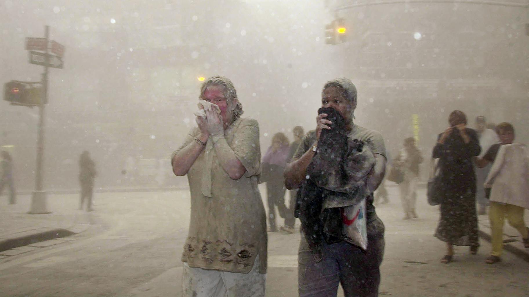 In this Sept. 11, 2001 file photo, people covered in dust from the collapsed World Trade Center buildings, walk through the area, in New York. (AP Photo / Suzanne Plunkett, File)