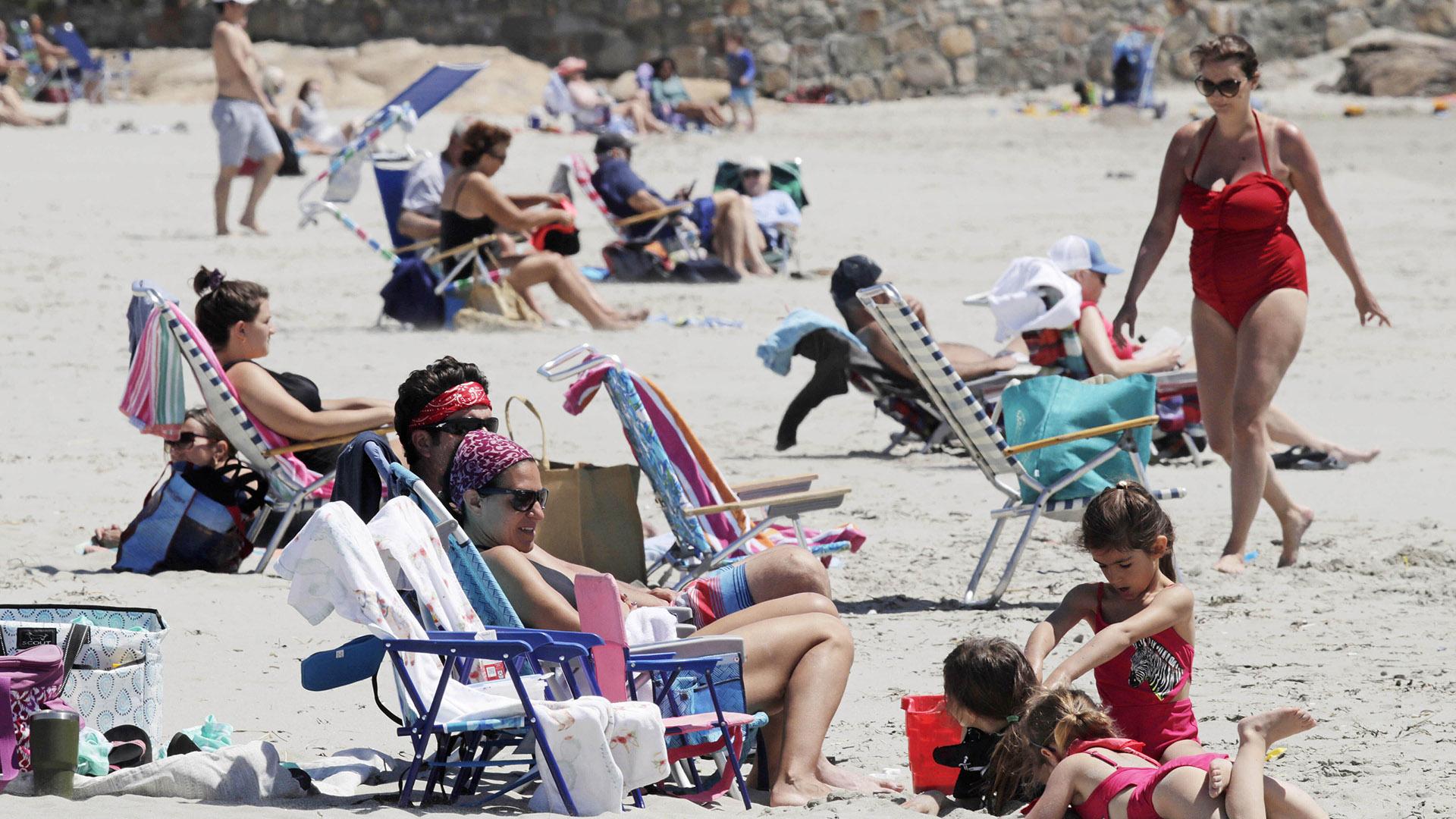 Beachgoers relax on the shore at Good Harbor Beach in Gloucester, Mass., Friday, May 22, 2020. Beaches in Gloucester reopened with restrictions on Friday after being closed two months ago due to the pandemic. (AP Photo / Charles Krupa)